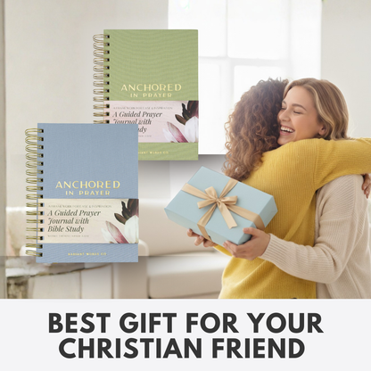 Two people hugging with 'Anchored in Prayer' journals and a gift in the foreground, with text overlay.