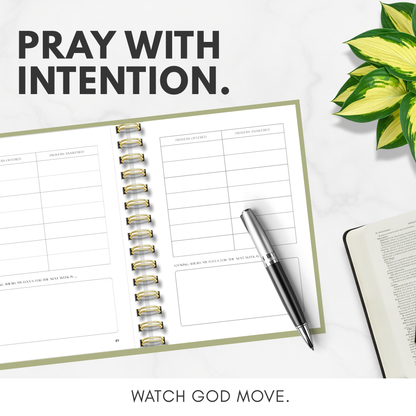 Open planner with pen and plant on a white surface, featuring motivational text.